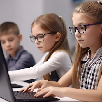 Niños enfocados usando computadoras